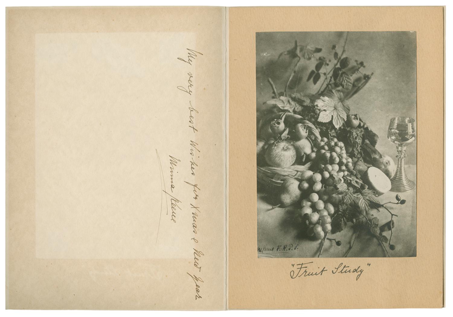 A bundle of fruits with an empty wine glass sitting beside them. Mounted on beige paper with the words “fruit study” written underneath. Black and white photograph by Minna Keene.