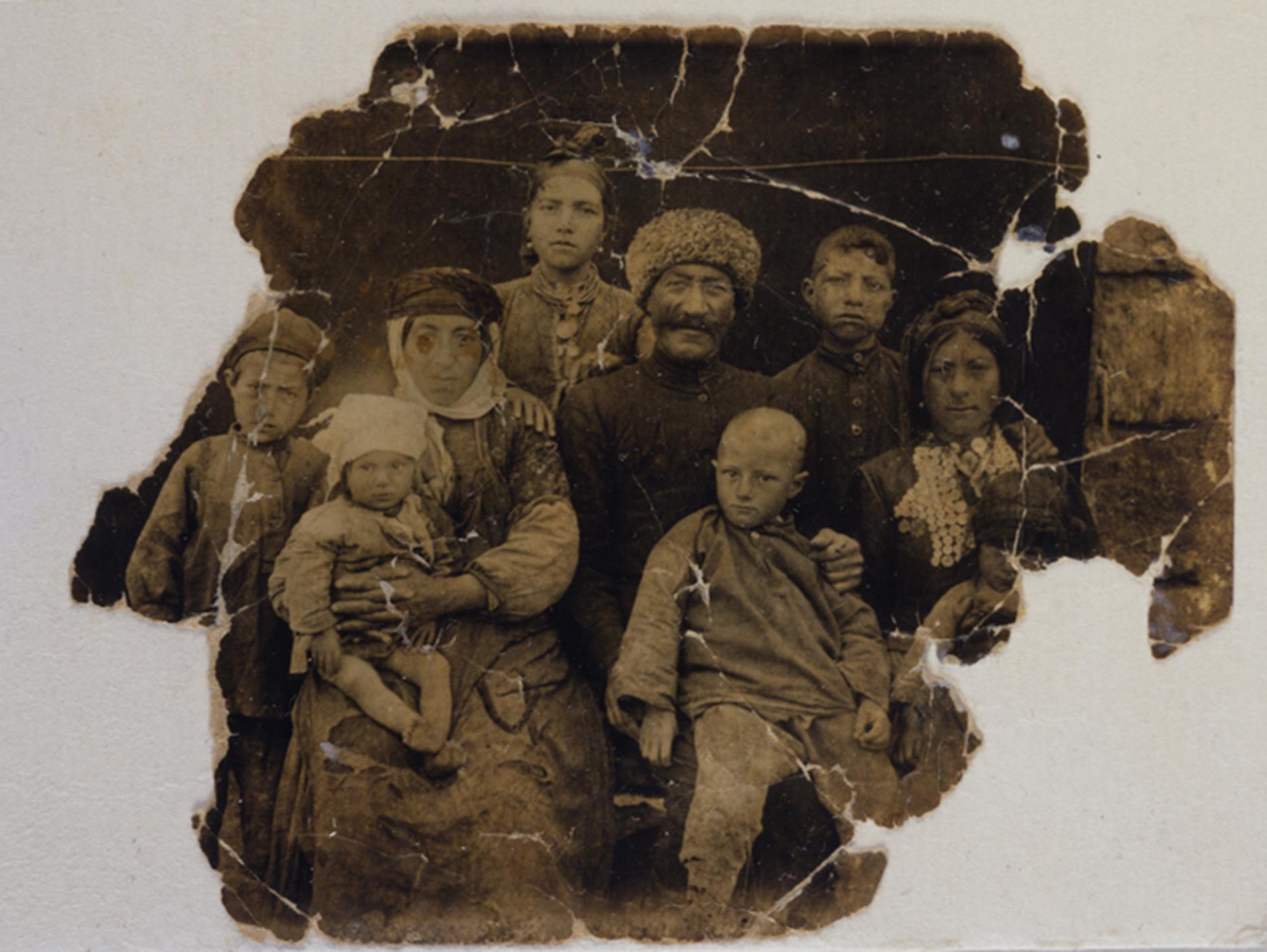 An old, torn photograph of a large family