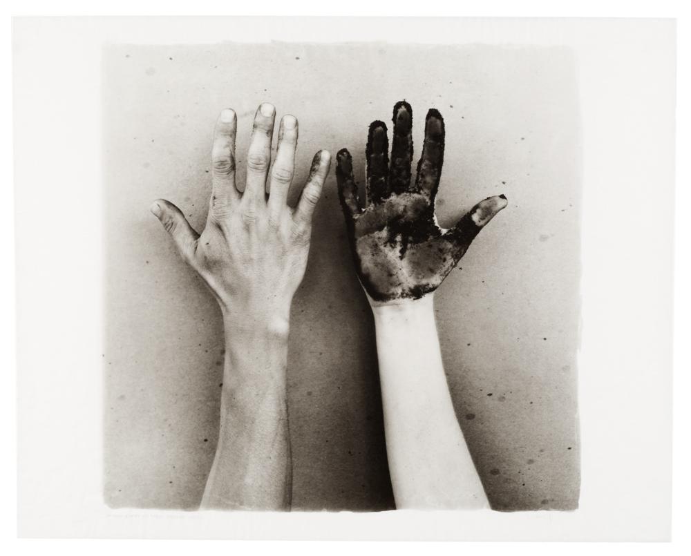Two hands reaching up, one is covered in dirt