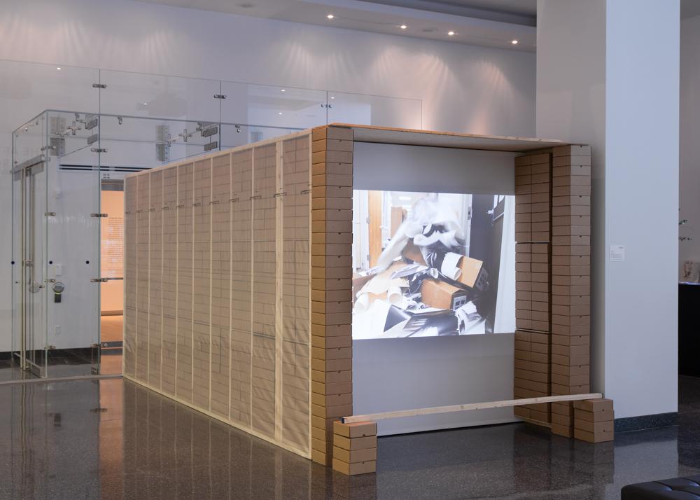 A screen sits inside a structure made of boxes and wood planks