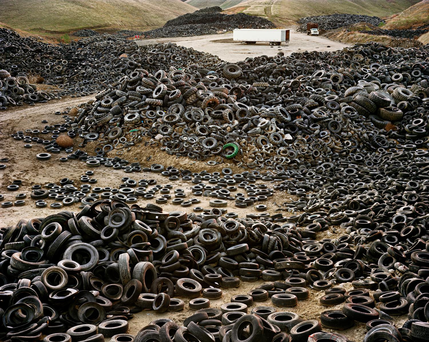Photograph by Edward Burtynsky. Multiple piles of tires.