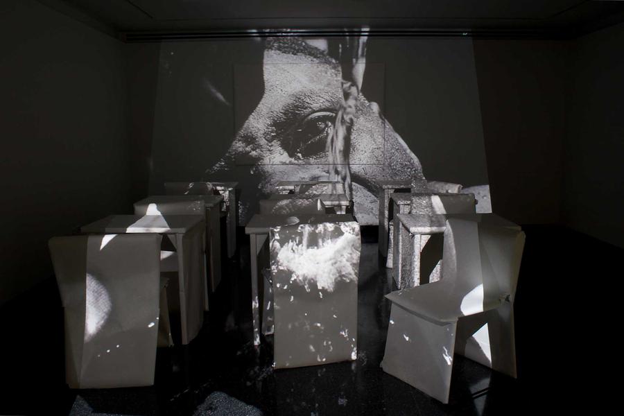 An image projected on to chairs in a dark room
