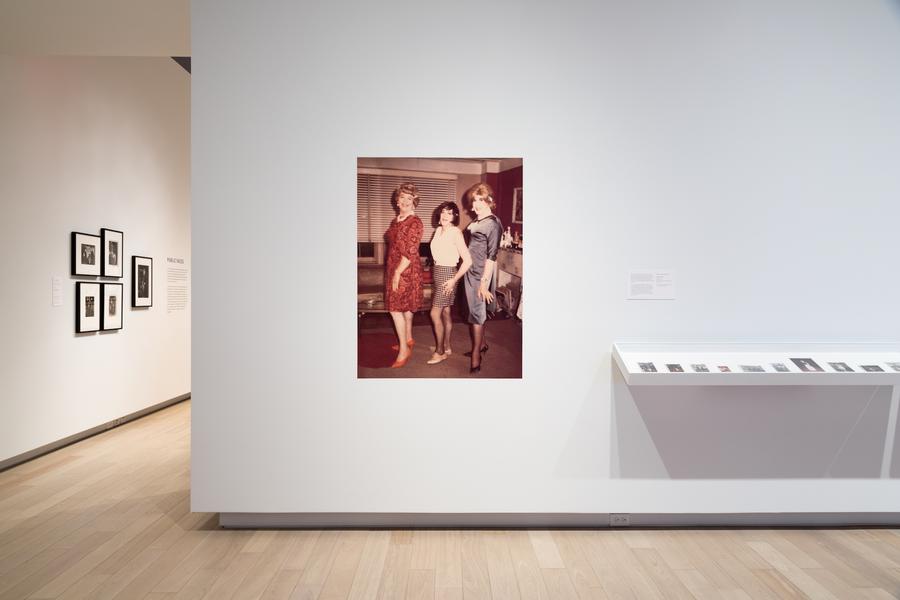 A large print of three women posing, beside a display case in the main gallery