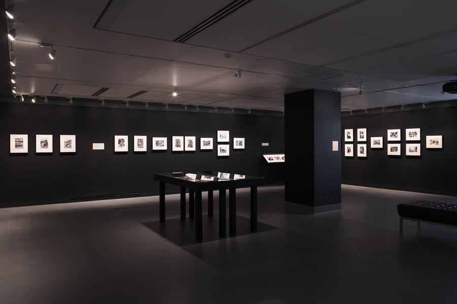 A gallery with black walls and white photographs