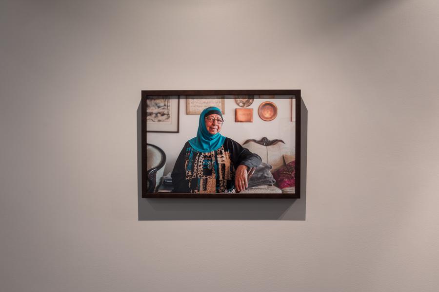 One framed photograph of a woman wearing a bright blue headscarf hanging on a wall