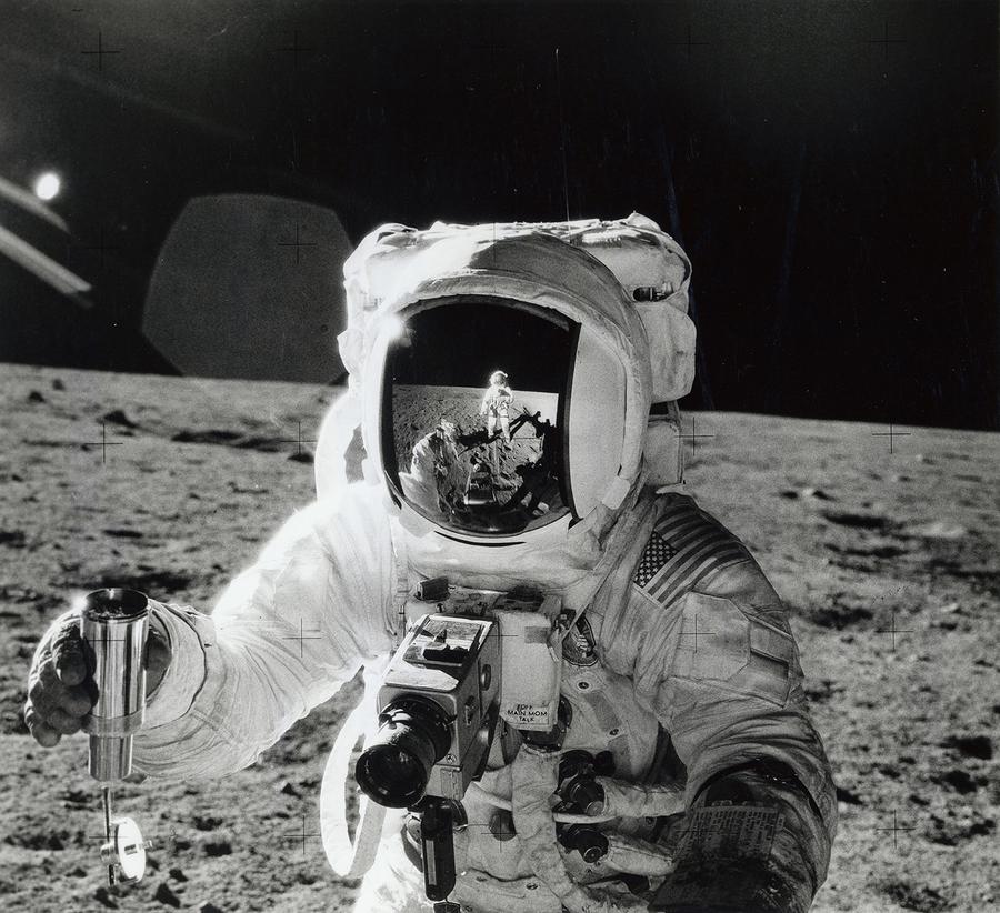 A astronaut on the moon, the image of another astronaut reflected in his helmet