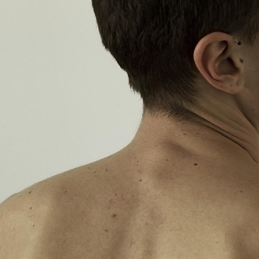 A man's shoulder and upper back, neck slightly turned to the right