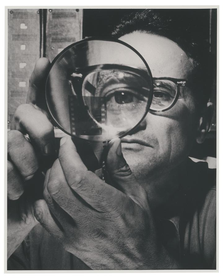 Self-portrait by Andreas Feininger holding a magnifying glass in front of his eye.