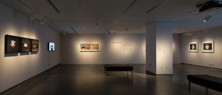 Wide shot of exhibition space, two black benches in the center