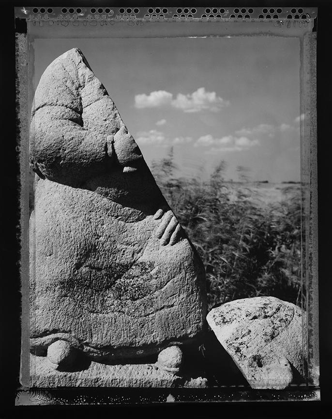 Rock sculpture of a man, cracked diagonally