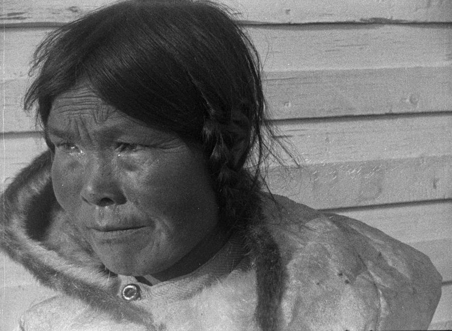 An Inuit woman in a heavy jacket and braided hair