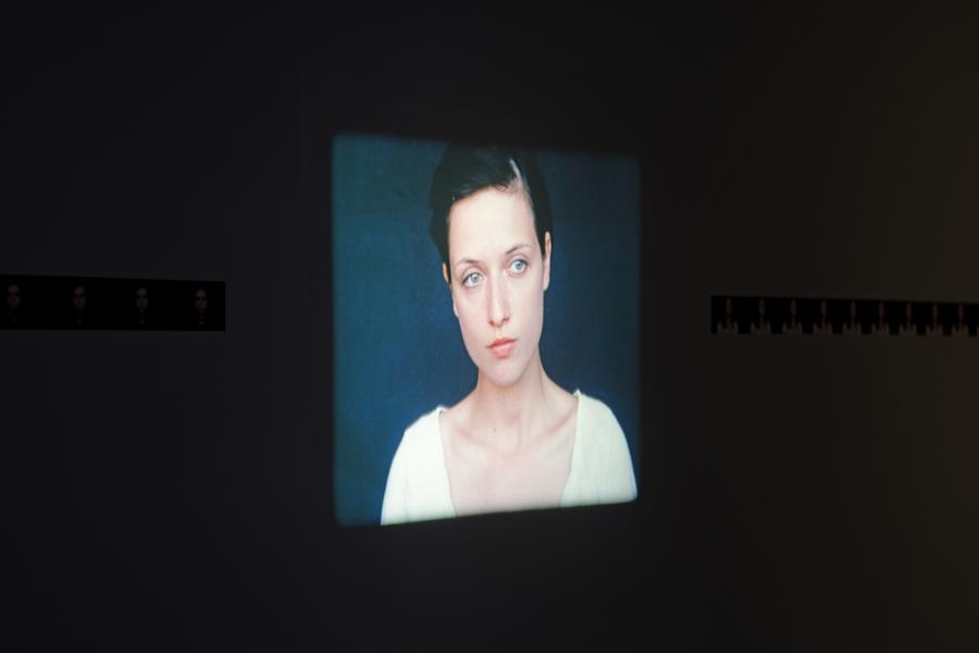 Video still of a dark-haired woman in a white shirt