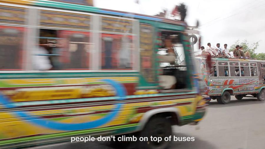 Blurry video still of a bus in motion. Text reads "people don't climb on top of buses"
