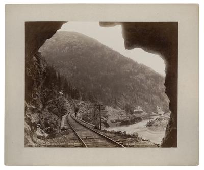 A photograph of a canyon and railroad tracks, taken in 1887